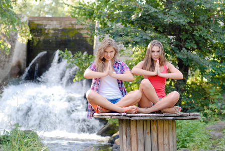 两个少女坐在瑜伽的立场