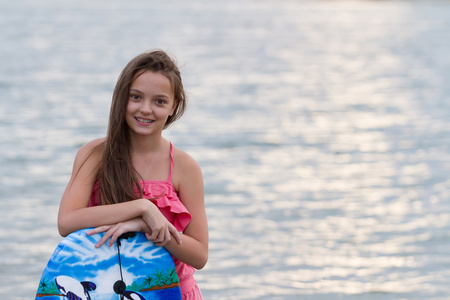 年轻的女孩带着笑容的冲浪板
