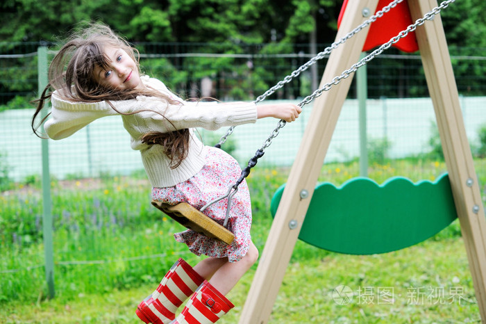 在公园里荡秋千的优雅儿童女孩