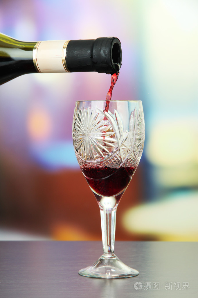 被注入到在明亮的背景上的红酒杯红酒