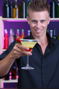 英俊男服务员准备鸡尾酒，在酒吧的肖像