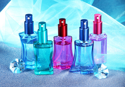 妇女在蓝色背景上的美丽瓶中的香水