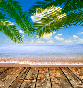热带海洋和沙滩与棕榈叶和木地板