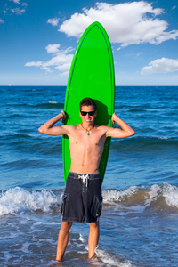 男孩青少年冲浪者在海滩举行的冲浪板