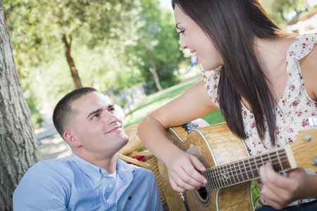 混的血情侣在公园玩吉他和唱歌