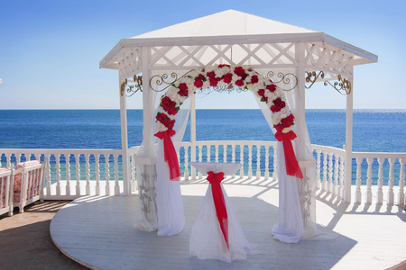 与拱在海滩上的白色婚礼馆
