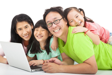幸福的亚洲家庭与便携式计算机
