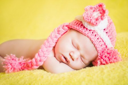美丽睡觉的婴孩穿条纹的帽子