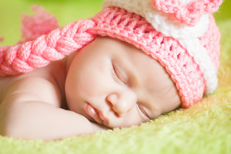 美丽睡觉的婴孩穿条纹的帽子