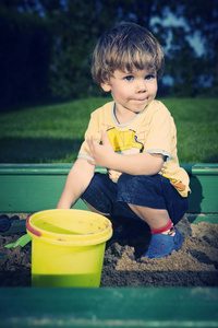 小男孩在花园里的房子附近在家玩各种玩具