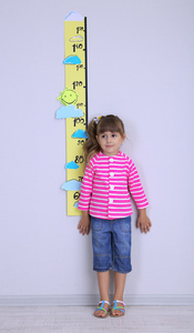 测量高度在房间的墙上的小女孩图片