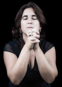 西班牙裔美国人的女人，她闭着眼睛祈祷
