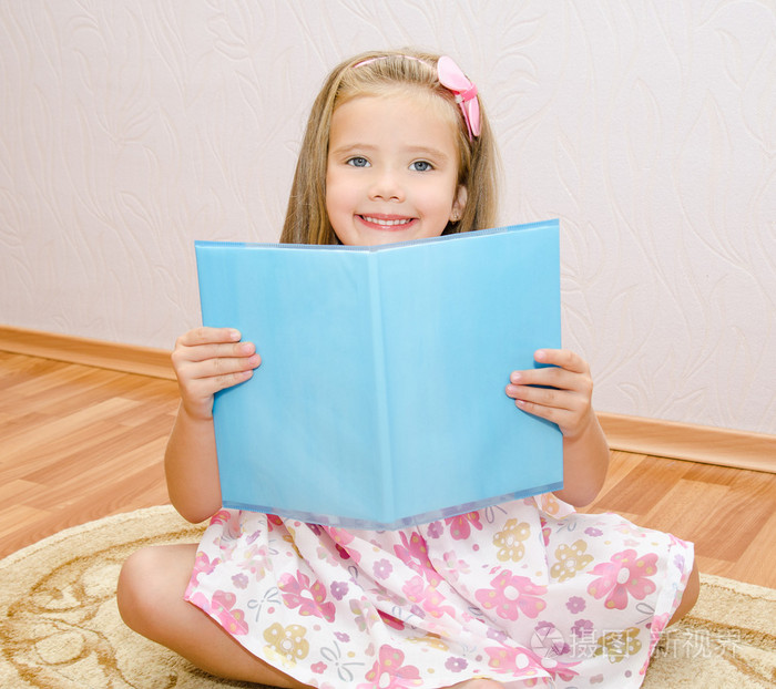 可爱微笑的小女孩读一本书