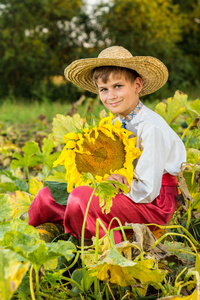 快乐的小男孩在花园举行向日葵