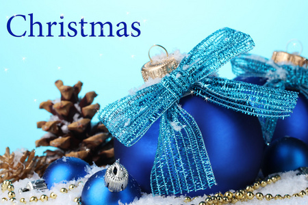 美丽的蓝色圣诞球和锥体在蓝色背景上的雪