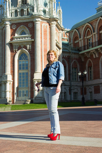 一个女人在蓝色外套走在 t tsaritsyno 宫附近