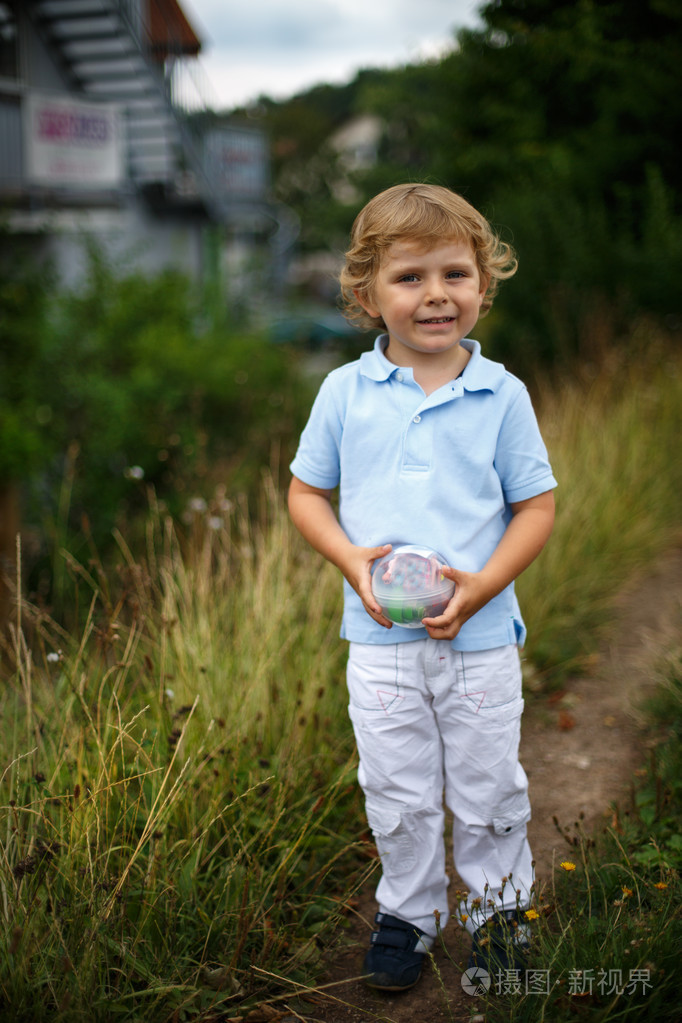 漂亮的小男孩走在一条乡间