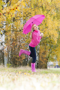 女人穿橡胶靴与伞在秋季性质