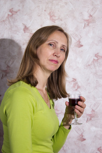 一名女子与一杯红酒的绿色上衣