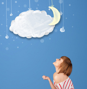 年轻的女孩低头看卡通的晚云与月亮