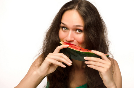 美丽的女人吃绿色成熟的瓜切片