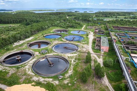 在绿色的树林里污水处理厂泥浆处理处理婴儿奶瓶在黑色背景用于存储水