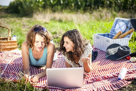 两个漂亮的女生做一次野餐和检查计算机
