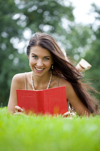 年轻美丽的年轻女子，读一本书户外