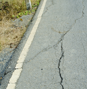 破碎的沥青。沥青道路一侧的崩溃是侵蚀