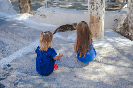小女孩玩街头的商场 希腊，圣托里尼岛上一只猫