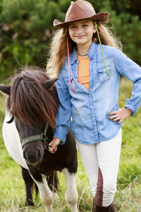 牧场可爱的女孩在农场里的小马