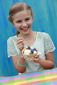 夏季糖果可爱的女孩吃与蓝莓冰淇淋