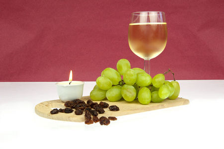 白色酿酒葡萄和葡萄干与蜡烛
