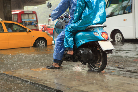 两个男人穿着雨衣骑摩托车