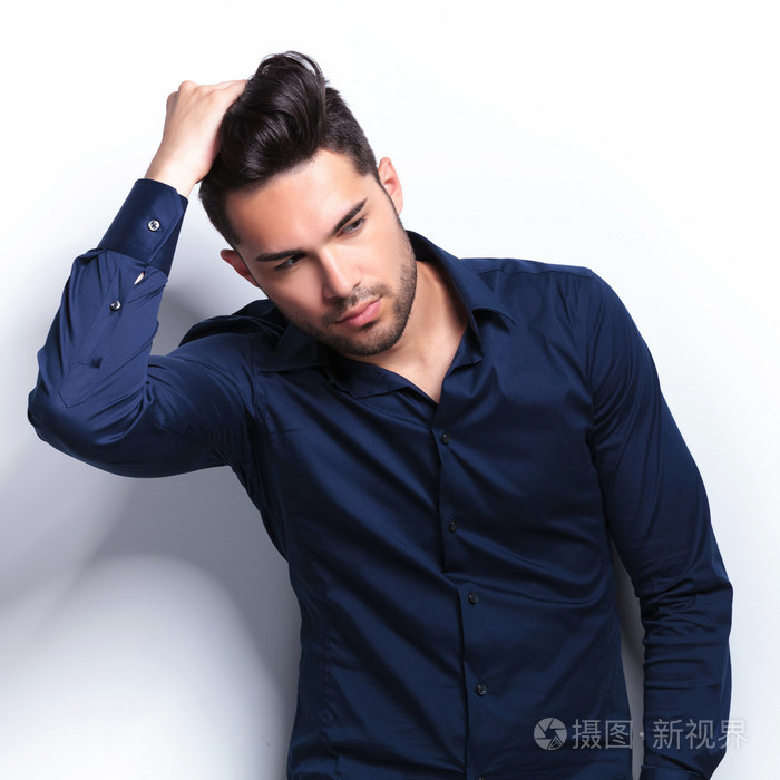 整理他的头发的年轻男子的特写