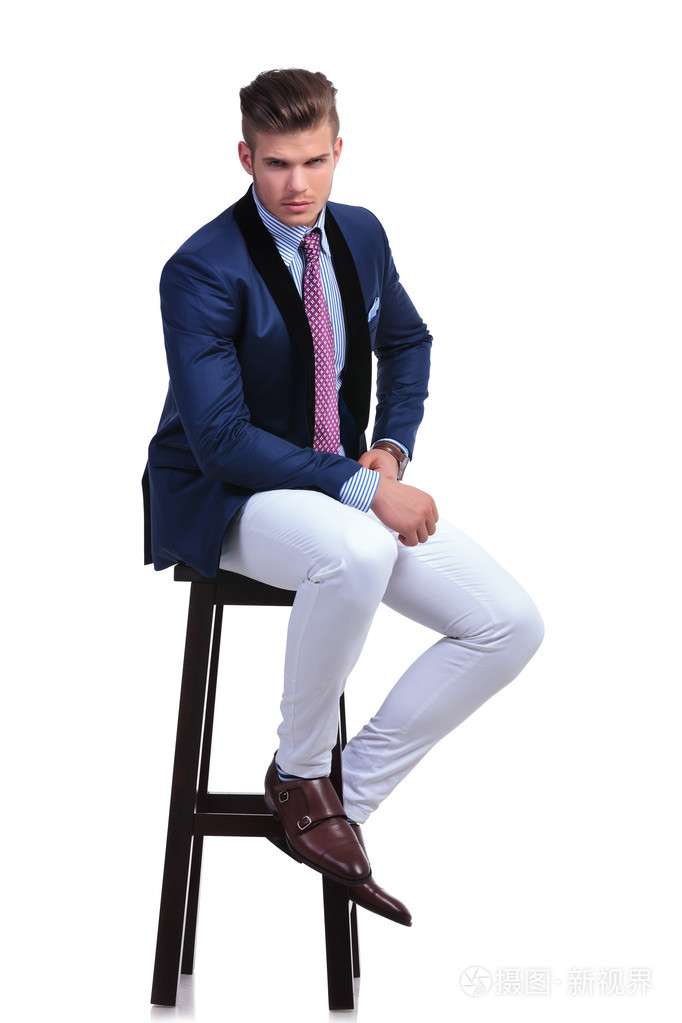 坐着的年轻商业男人用手在他的臀部