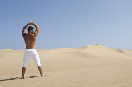 沙漠沙丘的肌肉的男人