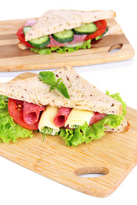 美味三明治与萨拉米香肠和蔬菜上切板 白底隔离