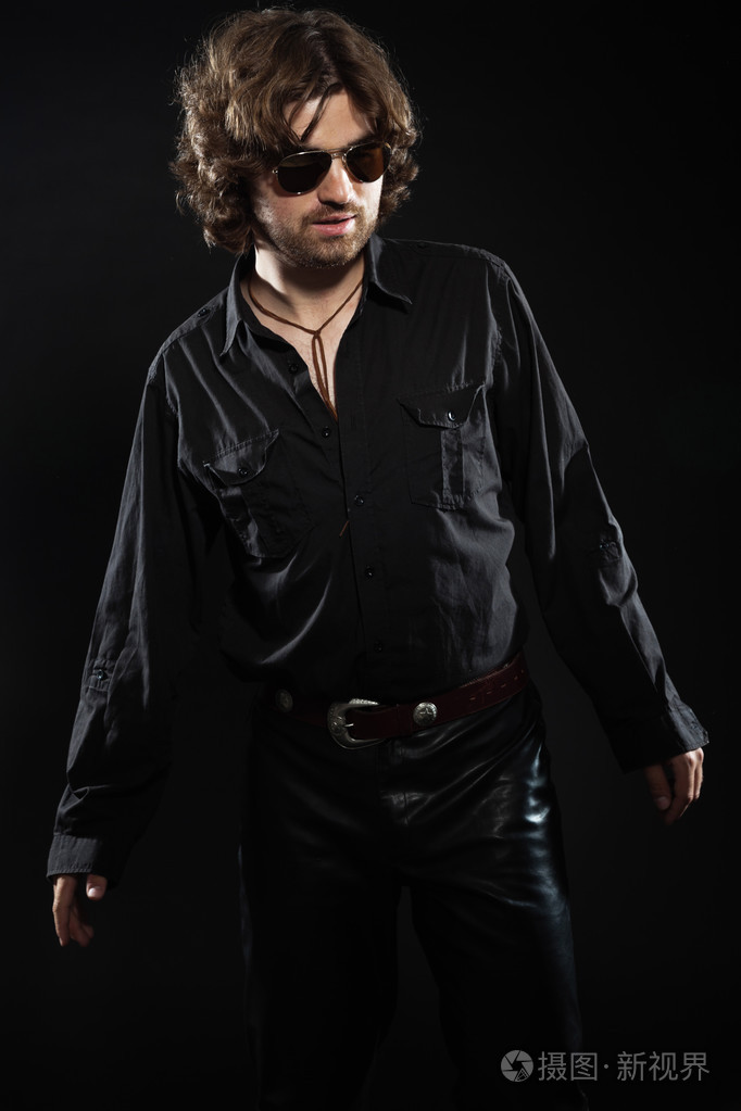 酷摇滚风格舞蹈与长长的棕色的头发和胡子的音乐家照片-正版商用图片