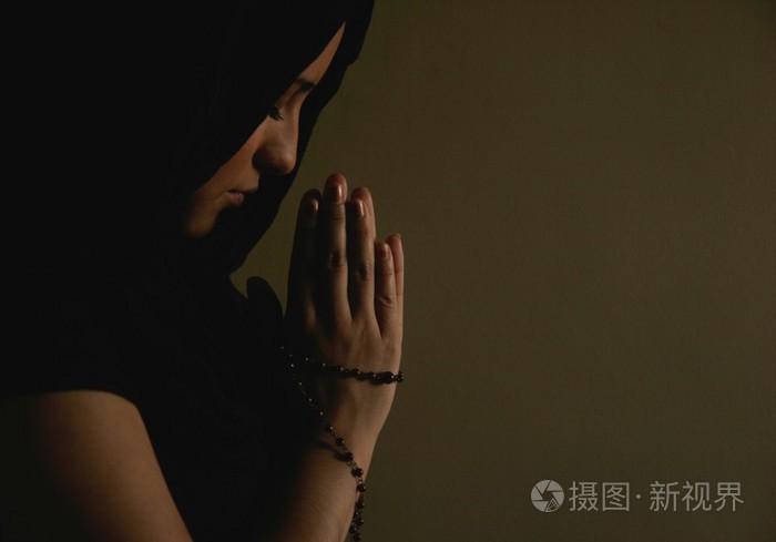 拨弄着念珠祷告的女人