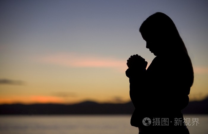 一名少女在日落祈祷