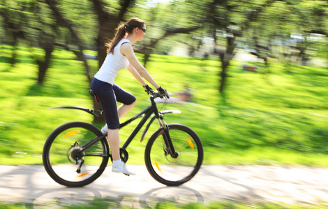 漂亮女人与自行车的绿色公园