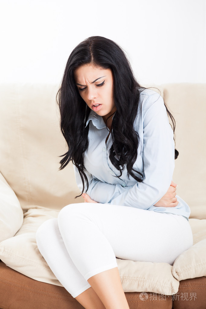 生病的女人握着的手上胃疼