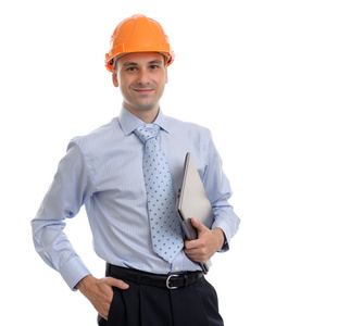 年轻男性建筑师戴着头盔和控股的笔记本电脑
