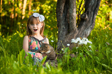 小椒女孩和一只猫在公园里一起玩