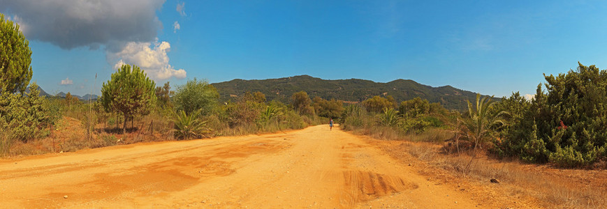 全景拍摄的砂路在绿山风景。希腊。肺心病