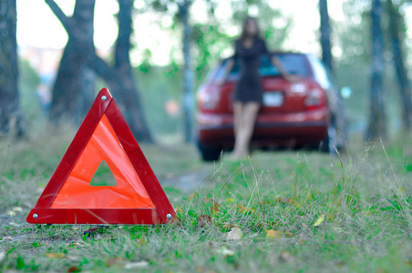 紧急道路标志与一个年轻的女孩和一辆汽车在艾菲尔铁塔的背景