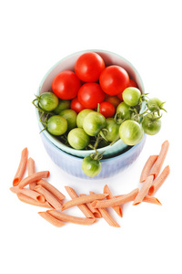 原始的意大利面食，在白色背景上的红色和绿色的西红柿