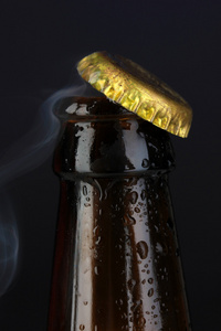 顶部打开湿的啤酒瓶上黑的背景