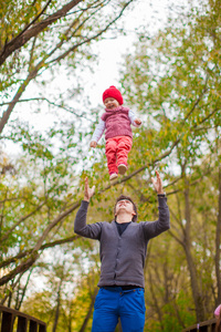 年轻的父亲与他可爱的小女儿在公园里玩得开心户外